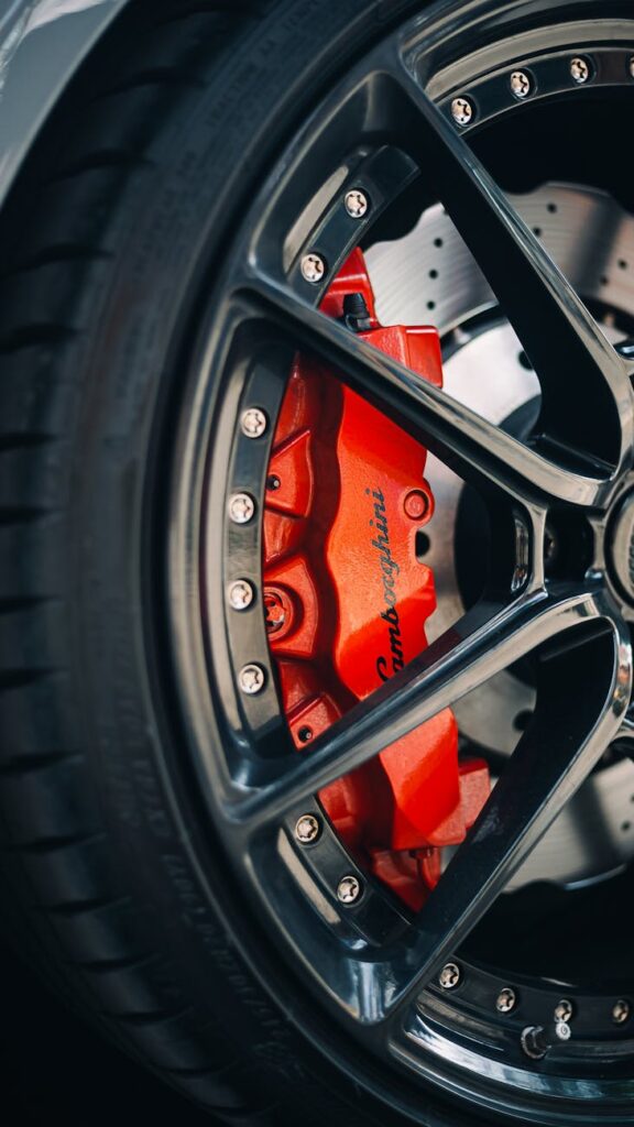 Detailed shot of a Lamborghini brake disc with red brake caliper, showcasing luxury and precision.